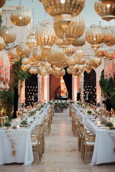 a long table is set up with white linens and gold chairs for an elegant dinner