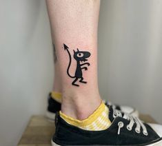 a person with a small tattoo on their leg that has a cat in the shape of a mouse