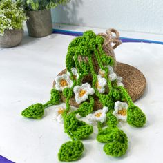 a crocheted plant sits on top of a table