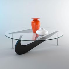 a glass table with an orange vase on top and a white vase sitting next to it