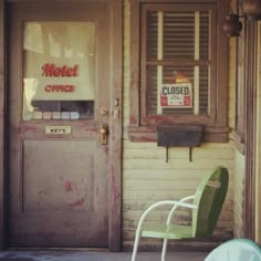 a green chair sitting in front of a closed door with a sign that reads motel office