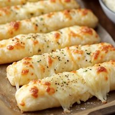 several pieces of bread with cheese and seasoning on them sitting on a baking sheet