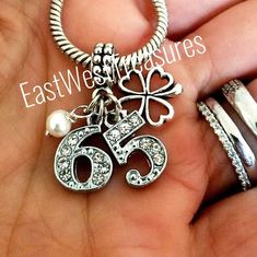 a person is holding two rings and a necklace in their hand with the number 66 on it