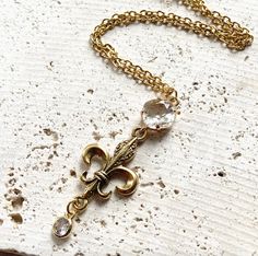 This beautiful gold hand casted fleur de lis necklace has a vintage vibe to it. 18” non tarnish chain with a 2.5” pendant drop Gold Dangle Jewelry With Antique Finish, Elegant Gold Necklaces With Antique Finish, Elegant Gold Necklace With Antique Finish, Elegant Tarnish-resistant Bronze Necklace, Gold Hand, Vintage Vibe, Gold Hands, Vintage Vibes, It Cast