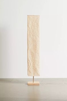 a piece of paper is standing on a wooden stand in front of a white wall