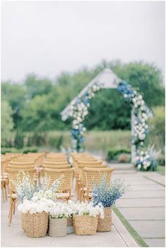 an outdoor ceremony set up with wicker chairs and flowers