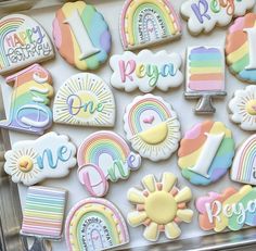 decorated cookies are displayed in a clear plastic box with the words, happy birthday, and rainbows on them