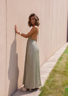 Unleash your inner beach babe in our Sydney Sundress! This olive halter neck sundress is the perfect addition to your summer wardrobe. Not only does it keep you cool in the sun, but its playful halter neck adds a touch of flirty flair. Bring on the sunshine (and compliments)! Fabric 97% polyester, 3% spandex Chic Backless Maxi Dress For Summer, Summer Poolside Halter Top With Spaghetti Straps, Summer Maxi Backless Dress For Day Out, Chic Backless Sundress For Beach, Chic Summer Backless Dress For Vacation, Beach Season Backless Dress With Tie Back, Green Maxi Backless Dress For Beach, Summer Backless Maxi Dress For Beach Season, Green Backless Maxi Dress For Beach