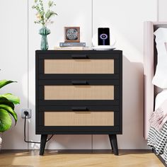 a black and beige chest of drawers next to a bed