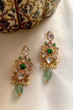 Gold toned, 925 silver dangler earrings with bead drops, moissinite polki and green stone embellishments.
Type: Moissinite Polki
Composition: 925 Silver
Color: Green,Gold
Other Details: 
Dimensions: L x B (in inches): 2 x 0.6
Disclaimer: This is a handcrafted product containing semi-precious stones and may have slight irregularities or imperfections. These irregularities are the result of the human involvement in the process. Its made in sterling silver 925 hallmarked. - Aza Fashions Luxury Fusion Bridal Earrings In Green, Elegant Luxury Green Chandbalis, Luxury Green Hand Set Chandbalis, Jaipur Jewelry Aurus, Desi Jewellery, Jewelry Room, Indian Jewelry Set, Classic Jewelry Pieces, Wedding Jewelry Sets Bridal Jewellery