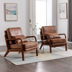 two brown leather chairs sitting on top of a rug