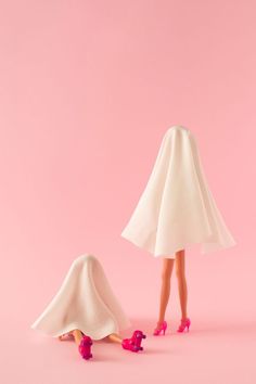 a woman in white dress and pink shoes standing next to a lamp shade on a pink background