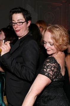 two women standing next to each other at a party