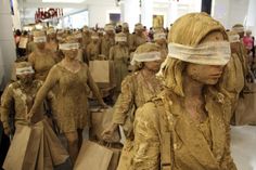 many people are covered in mud and plastic bags as they walk down the street with shopping bags on their heads