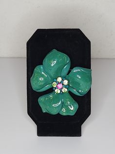 ITEM DESCRIPTION This is a vintage flower brooch.  It features kelly green enamel with yellow swirled in.  In the center are green, blue and pink rhinestones. See all photos please...they are part of the description. Markings/Stamps:  Unmarked MEASUREMENTS:  Found in photos - please review all photos  **Due to age, there may be a small amount of age flaws not deemed to be worthy of noting...straw marks, bubbles, some scuffing, some particles...as typical with age/production.  I will be glad to p Formal Green Enamel Brooches, Green Flower Shaped Enamel Pin Brooch, Green Flower Enamel Pin Brooch, Green Enamel Clip-on Jewelry, Green Flower-shaped Enamel Brooch Pin, Vintage Kelly, Vintage Green Rhinestone Brooch, Vintage Trifari, Enamel Flower