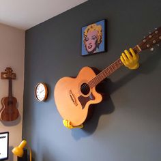 a guitar hanging on the wall next to a clock