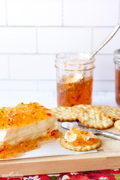 a cheese appetizer on a cutting board with crackers and honey in the background