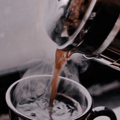 coffee being poured into a cup with steam coming from it