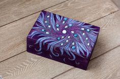 a purple and blue box sitting on top of a wooden floor