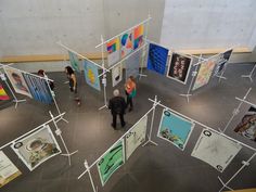 an overhead view of people looking at art on display