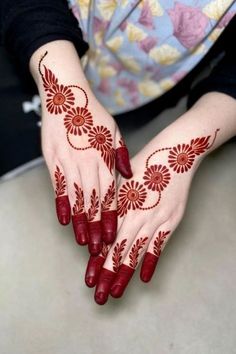 a woman's hands with henna tattoos on them