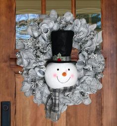 a snowman wreath hanging on the front door