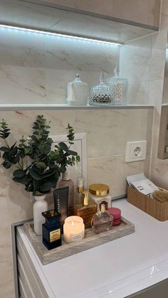 a bathroom counter with candles, soaps and other items on it