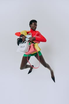 a woman is jumping in the air with her handbag