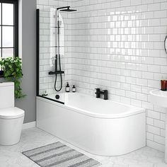 a white tiled bathroom with black and white accessories