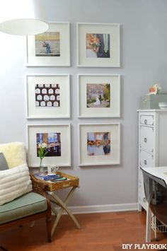 a living room with pictures on the wall and a chair next to a table in front of it