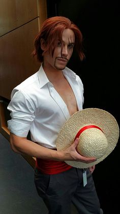 a man in white shirt holding a straw hat