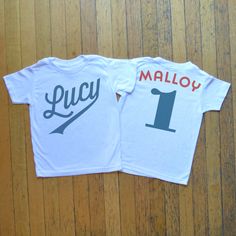 two t - shirts with the name and number on them sitting on a wooden floor