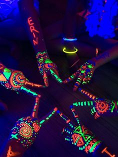 glow sticks are arranged in the shape of skeletons on a wooden floor with neon lights