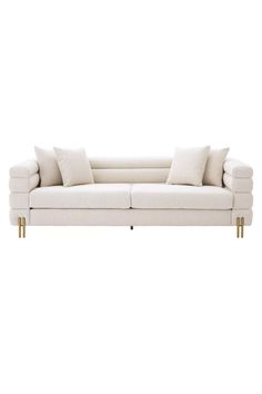 a white couch with two pillows on it's back and one arm extended to the side