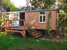 a small wooden cabin sitting on top of a lush green field