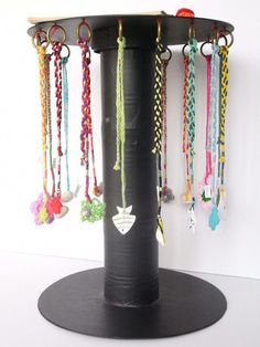 there is a black stand with many necklaces on it