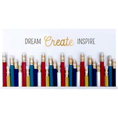 there are many different colored pencils lined up in a row and the words dream create inspire above them