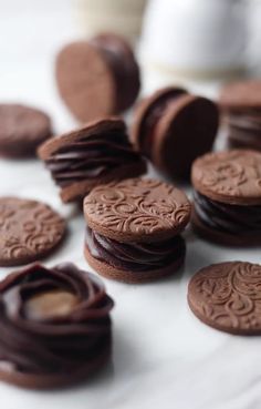 chocolate cookies are arranged on a white surface