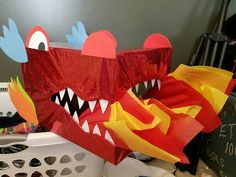 a paper cut out of a red monster with its mouth open and teeth wide open