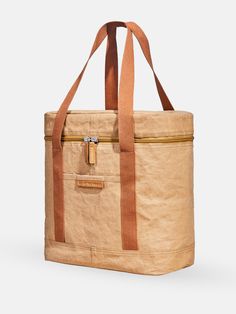 a tan canvas bag with brown leather handles