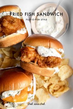 three fried fish sandwiches on a plate with chips