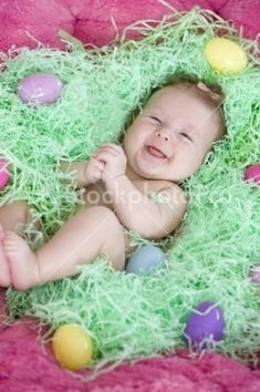 a baby is laying in some grass with eggs