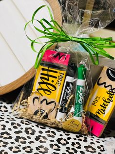 some candy bars wrapped in plastic wrap and tied with green ribbon on top of a leopard print table cloth