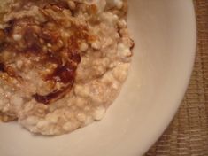 oatmeal with walnuts and raisins in a white bowl on a table