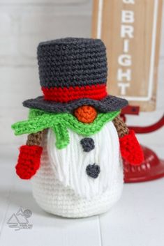 a crocheted snowman with a hat and scarf on it's head