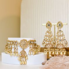 Preserve timeless charm into marvelous ensembles! With an absolute tale of elegance and sophistication, this set showcases the beautiful composition of thapa kundan and beaded work with contemporary decorative pearl moti details adorned with true craftsmanship. The set includes a necklace and a pair of matching earrings. Approximate earrings length is 4.5". Gold-plated on a high-quality brass as base metal. Made by order. Kindly allow 4-6 weeks for the delivery of this item. For custom or urgent Elegant Kundan Lehenga With Gota Work, Elegant Gold Sets With Mirror Work, Traditional Pearl Jewelry Sets For Reception, Temple Jewelry Pearl Chandbali Sets, Festive Chandbali Pearl Bridal Necklace, Festive Pearl Chandbalis In Temple Jewelry Style, Gold Chandbalis With Tilla For Designer Wear, Festive Hand Set Chandbali Pearl Necklace, Festive Chandbali Pearl Necklace Hand Set