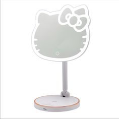 a hello kitty light up mirror on top of a white stand with an orange base