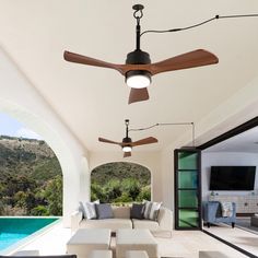 an outdoor living room with ceiling fans and couches next to a swimming pool area