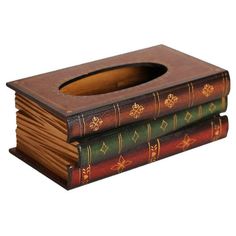 three books stacked on top of each other with a hole in the middle for toilet paper