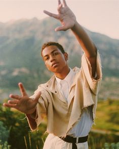 a young man holding his hands up in the air